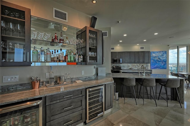 bar with appliances with stainless steel finishes, wine cooler, tasteful backsplash, and sink