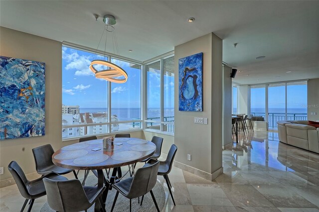 tiled dining room with floor to ceiling windows and a water view