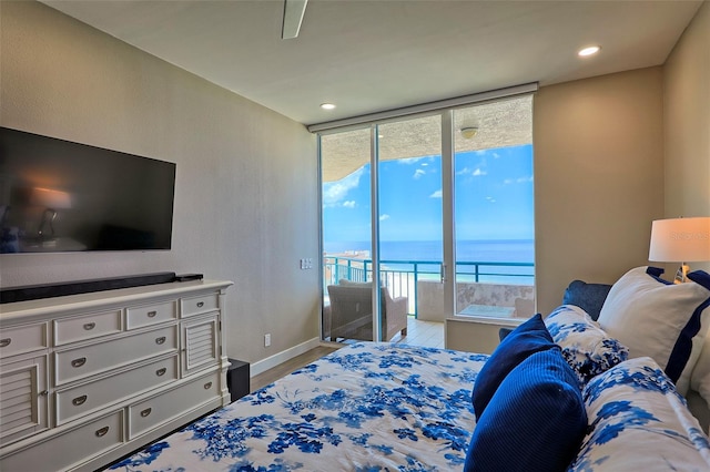 bedroom featuring ceiling fan, light wood-type flooring, a water view, and access to outside