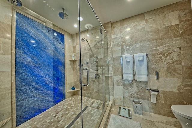 bathroom featuring a shower with shower door, tile walls, and toilet