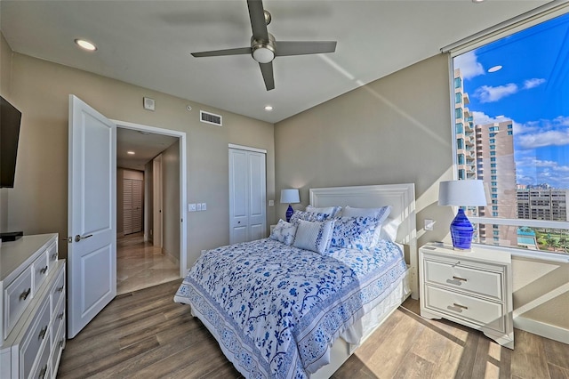 bedroom featuring ceiling fan, hardwood / wood-style flooring, and a closet