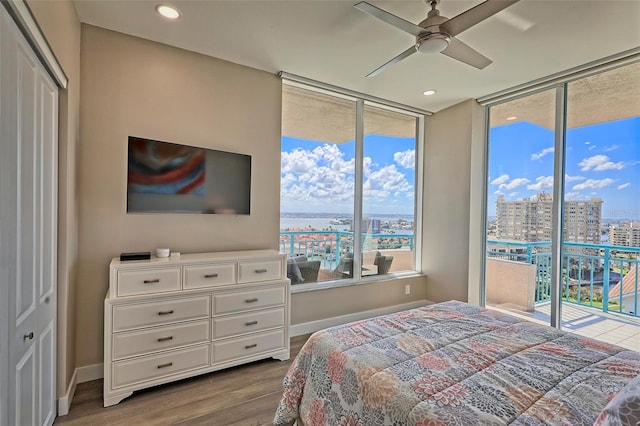 bedroom with hardwood / wood-style floors, a closet, access to outside, and multiple windows