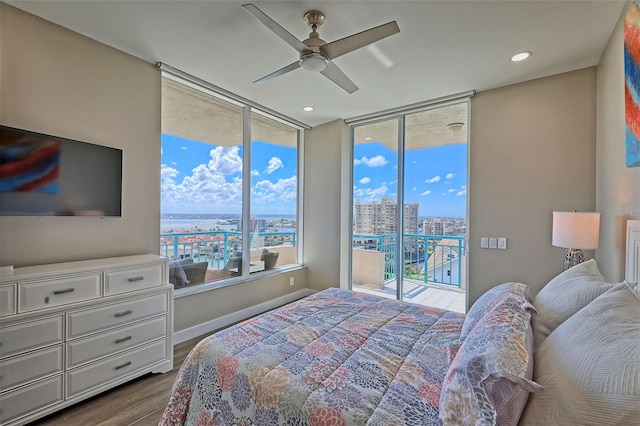 bedroom with access to outside, floor to ceiling windows, ceiling fan, and hardwood / wood-style flooring