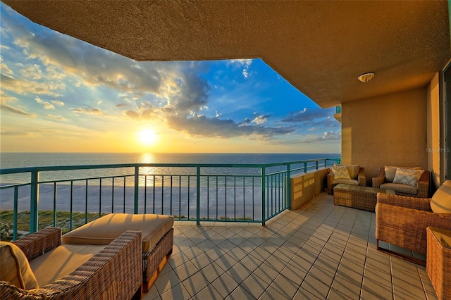 balcony at dusk featuring a water view and outdoor lounge area