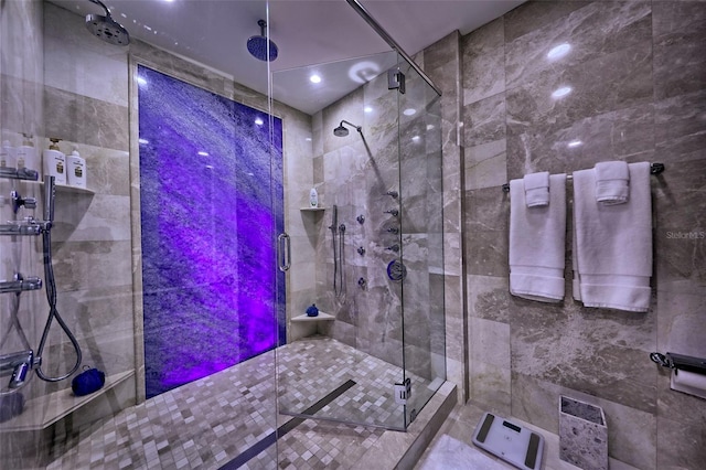 bathroom with tile walls, tile patterned floors, and a shower with shower door