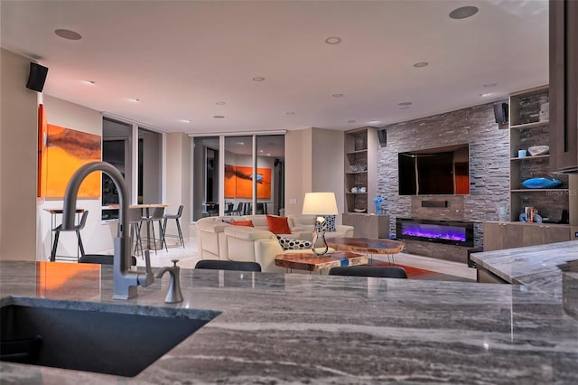 living room with tile patterned floors, sink, and built in shelves