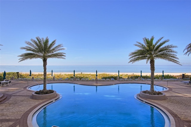 view of pool featuring a patio and a water view