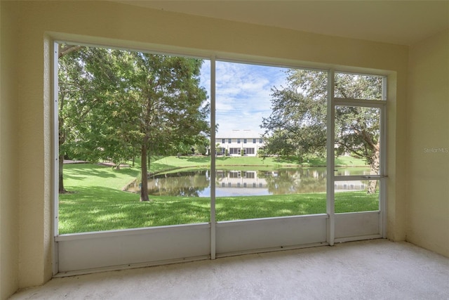 interior space with plenty of natural light, a water view, and light carpet