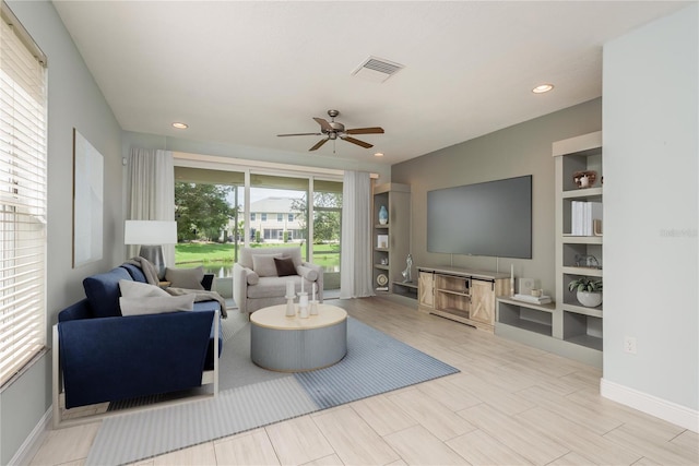 living room with ceiling fan and built in shelves