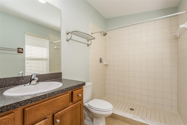 bathroom featuring tiled shower, vanity, and toilet