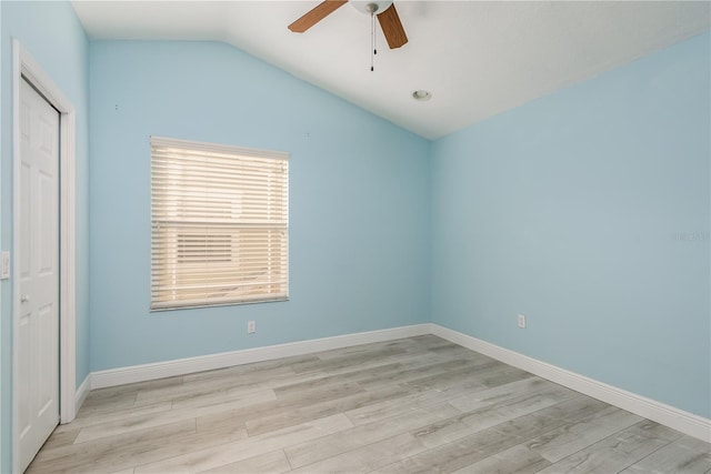 empty room with ceiling fan, lofted ceiling, and light wood-type flooring