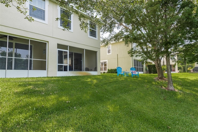 back of house with a yard and a sunroom