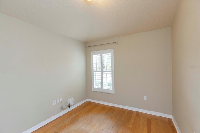 unfurnished room featuring a textured ceiling and light hardwood / wood-style floors