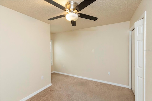 carpeted empty room with ceiling fan and a textured ceiling