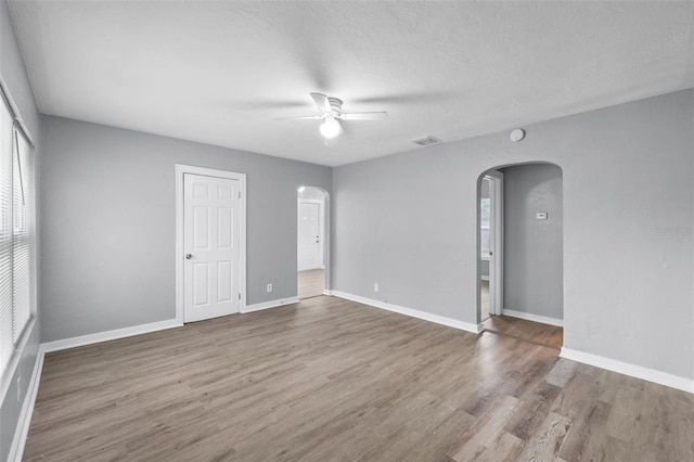 empty room with ceiling fan, a textured ceiling, and hardwood / wood-style flooring