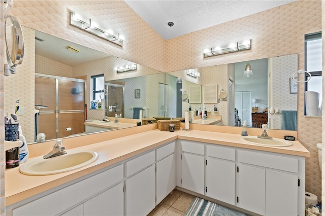 bathroom featuring vanity, a textured ceiling, plenty of natural light, and an enclosed shower