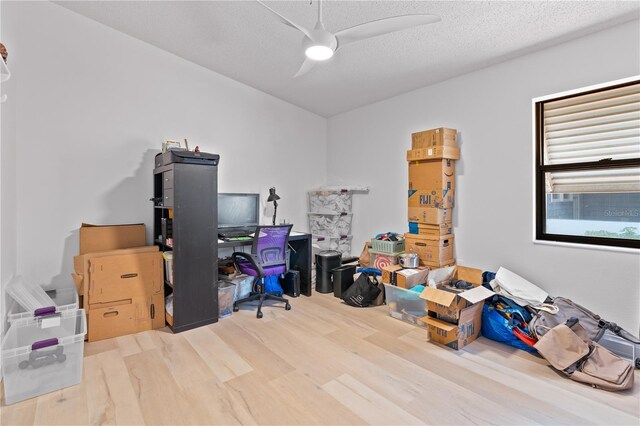 office space with a textured ceiling, ceiling fan, and light hardwood / wood-style floors