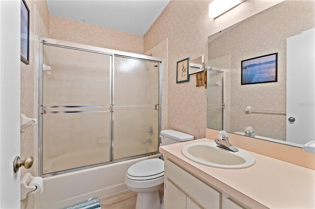 full bathroom with shower / bath combination with glass door, vanity, and toilet