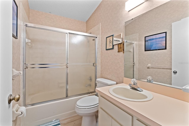 1967 Long Boat Dr, Lakeland, FL 33810 - full bath featuring combined bath / shower with glass door, toilet, vanity, a textured ceiling, and wallpapered walls