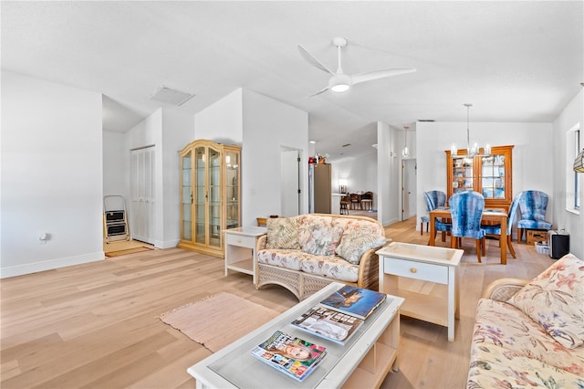 1967 Long Boat Dr, Lakeland, FL 33810 - living area with heating unit, vaulted ceiling, light wood-type flooring, ceiling fan with notable chandelier, and visible vents