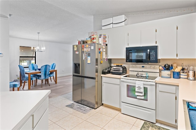 1967 Long Boat Dr, Lakeland, FL 33810 - kitchen with light tile patterned flooring, a chandelier, black microwave, stainless steel fridge with ice dispenser, and white range with electric cooktop