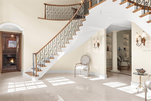2901 Leprechaun Ln, Palm Harbor, FL 34683 - stairs with baseboards, arched walkways, tile patterned floors, and a warm lit fireplace
