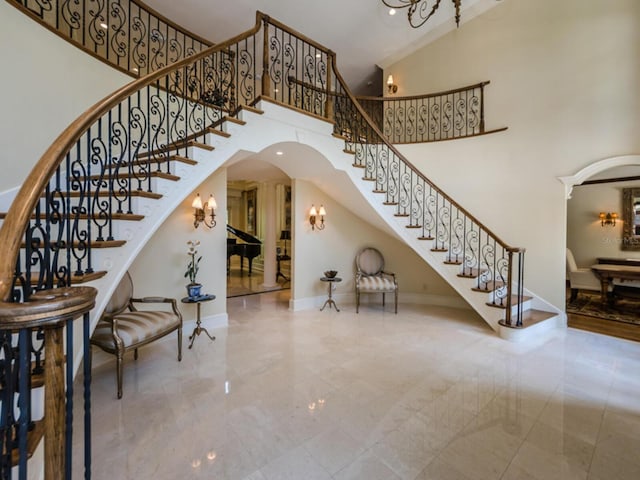 2901 Leprechaun Ln, Palm Harbor, FL 34683 - interior space featuring arched walkways, a high ceiling, an inviting chandelier, and baseboards