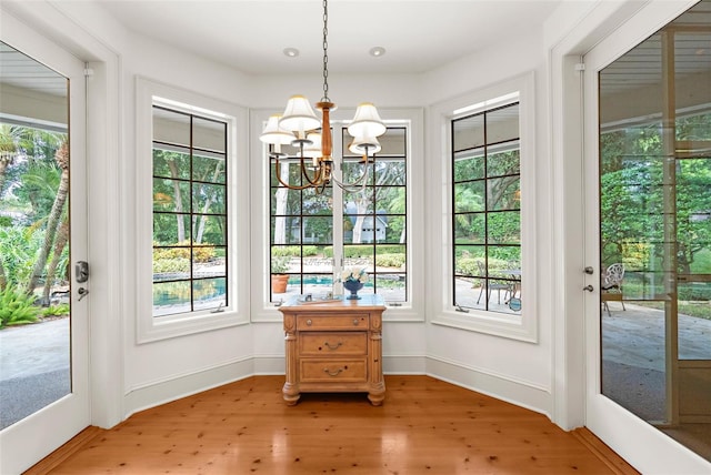 entryway featuring plenty of natural light, a notable chandelier, and light wood-type flooring