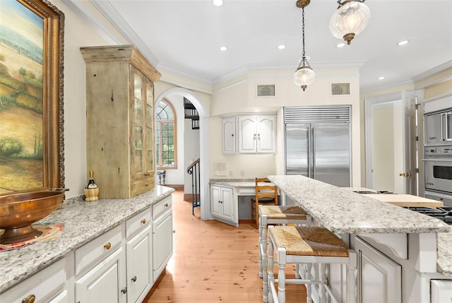 2901 Leprechaun Ln, Palm Harbor, FL 34683 - kitchen with visible vents, arched walkways, appliances with stainless steel finishes, and a kitchen breakfast bar