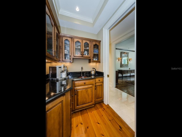 2901 Leprechaun Ln, Palm Harbor, FL 34683 - bar with wet bar, a sink, light wood-style floors, ornamental molding, and a tray ceiling
