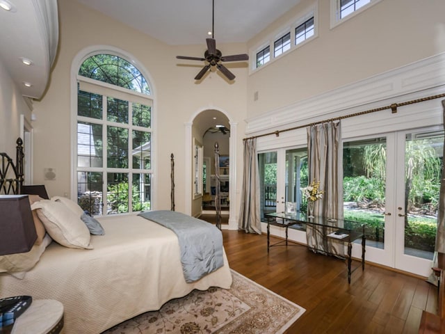 bedroom featuring french doors, multiple windows, ceiling fan, and dark hardwood / wood-style floors