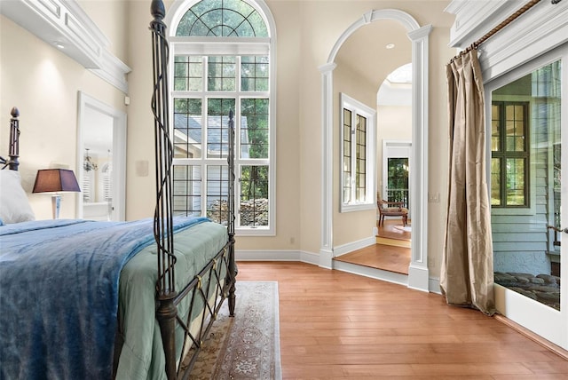 bedroom featuring light hardwood / wood-style floors and ornate columns