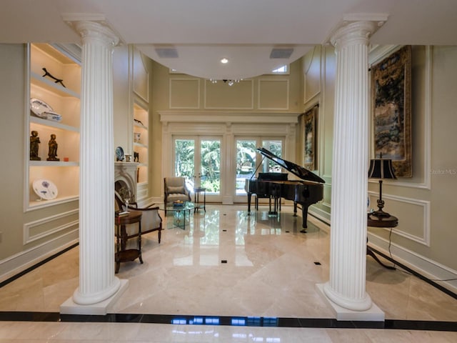 sitting room with built in features and decorative columns