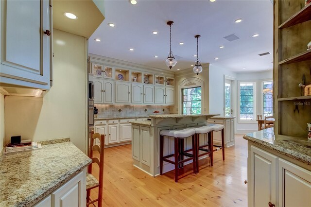 2901 Leprechaun Ln, Palm Harbor, FL 34683 - kitchen featuring light wood-style floors, open shelves, and a kitchen bar