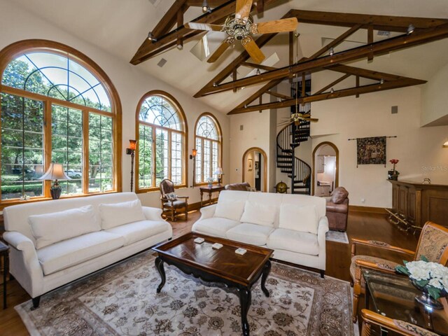 2901 Leprechaun Ln, Palm Harbor, FL 34683 - living room with a ceiling fan, beam ceiling, wood finished floors, stairway, and high vaulted ceiling