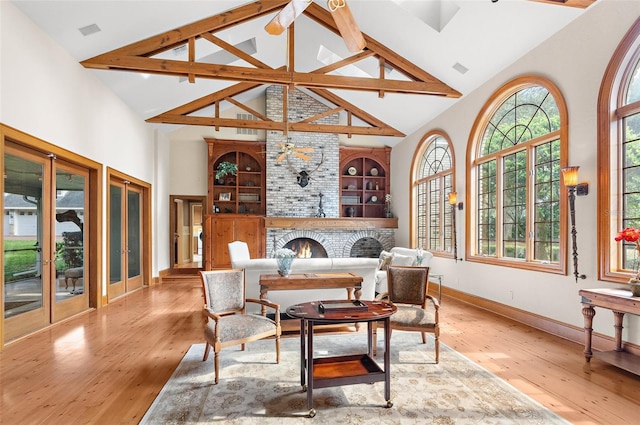 dining room with high vaulted ceiling, hardwood / wood-style flooring, a fireplace, and a healthy amount of sunlight