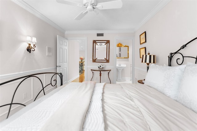 bedroom featuring crown molding, ceiling fan, and ensuite bath