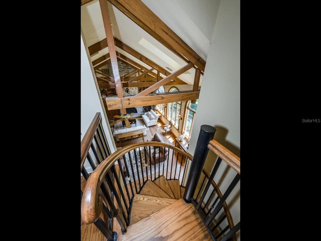 stairs featuring high vaulted ceiling, hardwood / wood-style flooring, and beamed ceiling