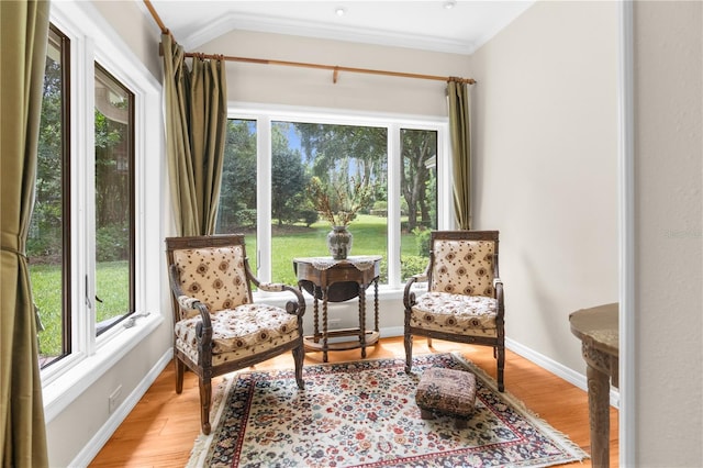 living area with ornamental molding and hardwood / wood-style floors