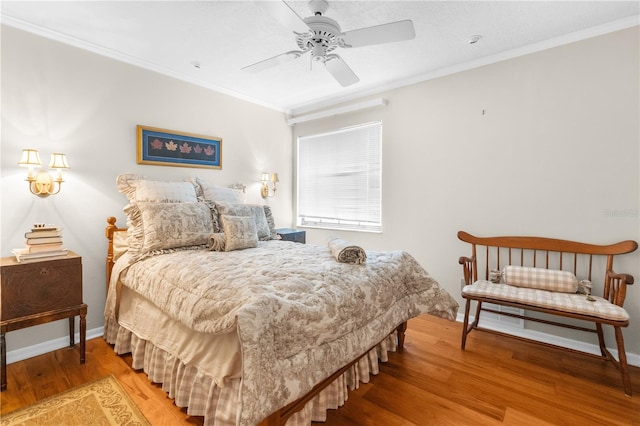 bedroom featuring ornamental molding, wood-type flooring, and ceiling fan