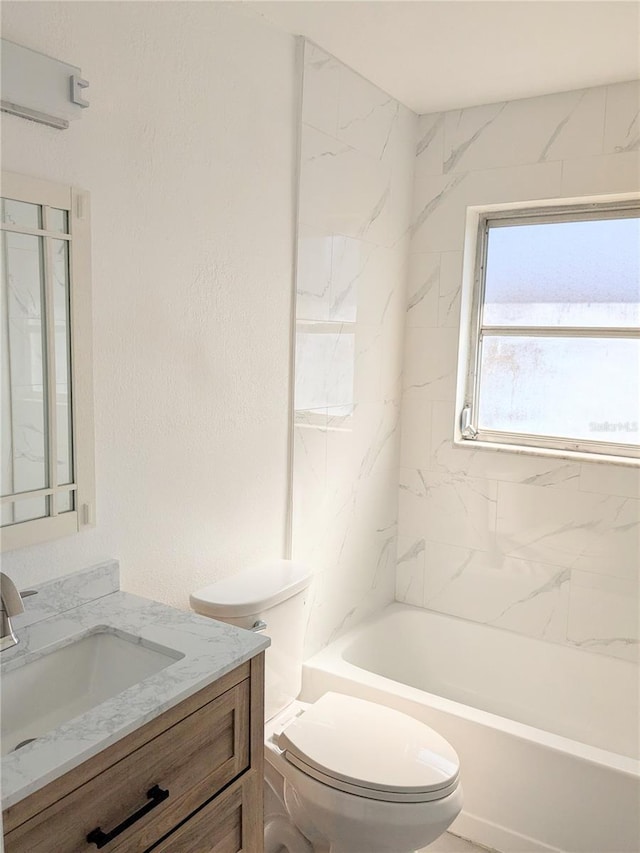 full bathroom featuring tiled shower / bath combo, vanity, and toilet