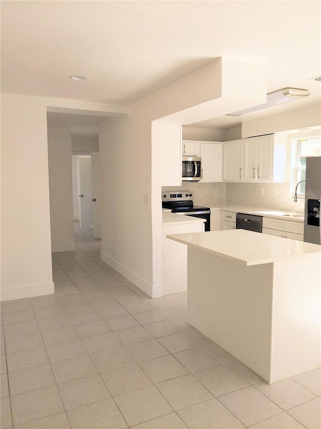 kitchen with white cabinetry, a center island, sink, tasteful backsplash, and appliances with stainless steel finishes