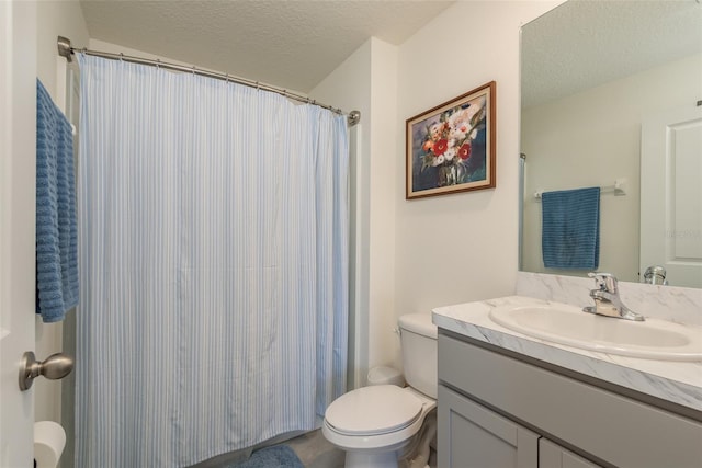 bathroom with a textured ceiling, toilet, and vanity