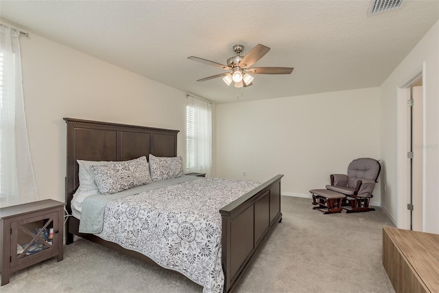 carpeted bedroom with a textured ceiling and ceiling fan