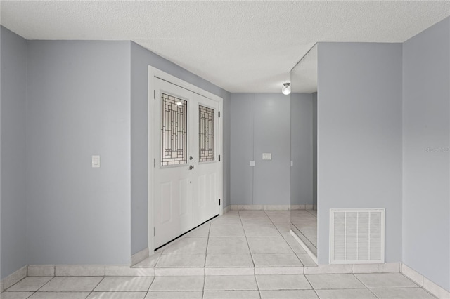 entryway featuring a textured ceiling and light tile patterned flooring