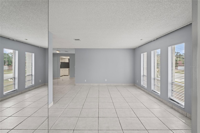 empty room featuring light tile patterned floors and a textured ceiling