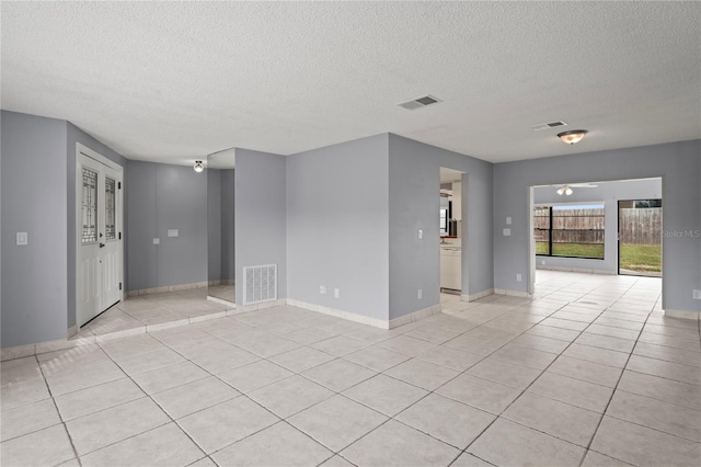 empty room with light tile patterned floors and a textured ceiling