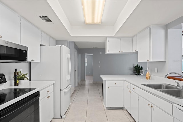 kitchen with white appliances, white cabinets, a raised ceiling, sink, and light tile patterned floors