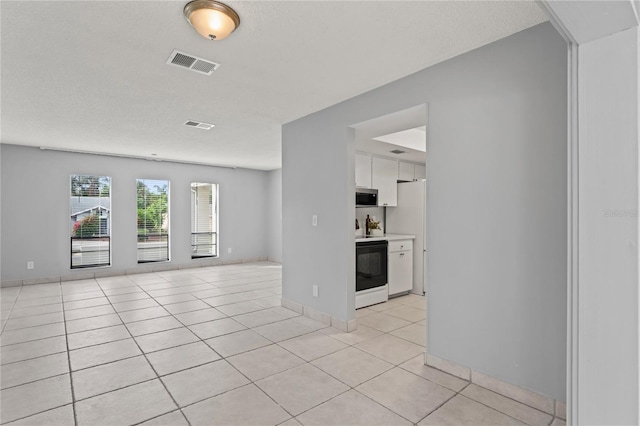 unfurnished living room with light tile patterned floors and a textured ceiling