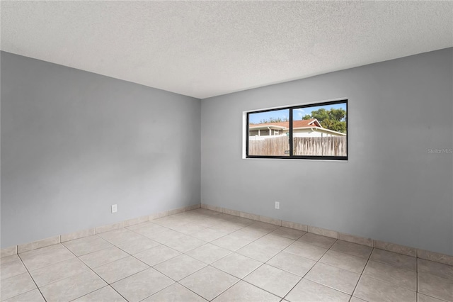 tiled empty room with a textured ceiling